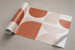 Vinil para Montras Personalizado 3 Folha de vinil impresso parcialmente enrolada, com grafismo terracota e creme e o suporte visível.
